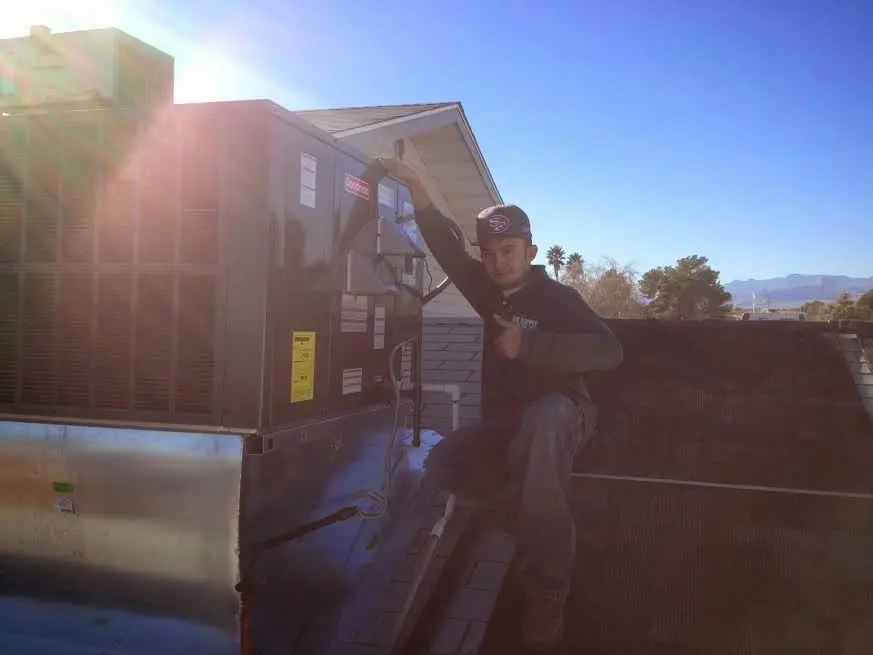HVAC technician performing Air Duct Repair on a rooftop unit in Kinnelon